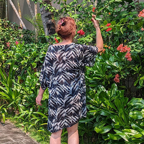 woman wearing LYC silk tunic looking at flowers