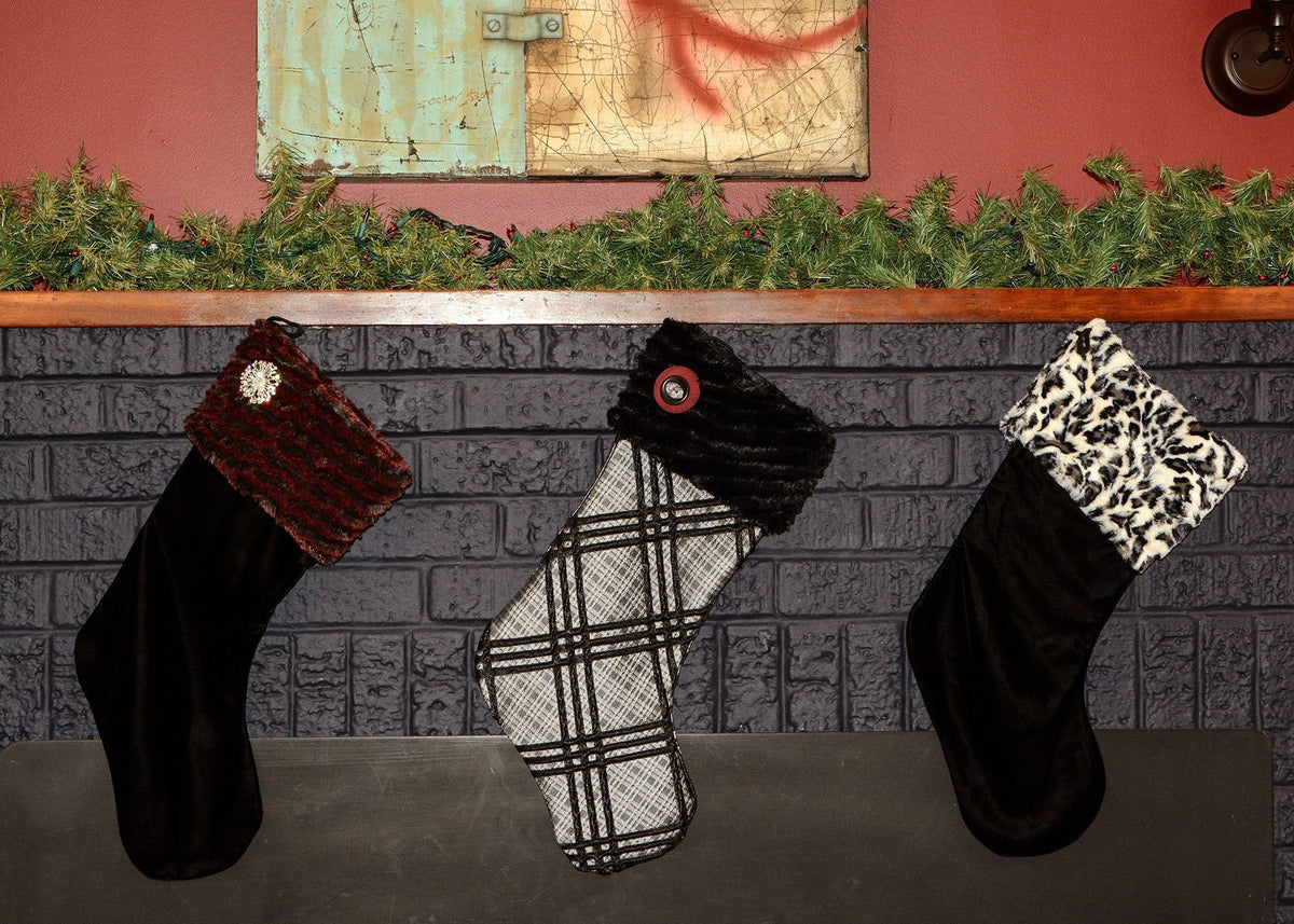 Three Holiday Stockings hanging on a Fire Mantle | Stocking - Desert Sand in Crimson with Cuddly Black Faux Fur Cuff |  Stocking - Silver Plaid Upholstery Fabric with Cuddly Black Faux Fur Cuff ||  Stocking - Cuddly Faux Fur Fur with White Jaguar Faux Fur Cuff | Handmade in Seattle, WA by Pandemonium Milliney
