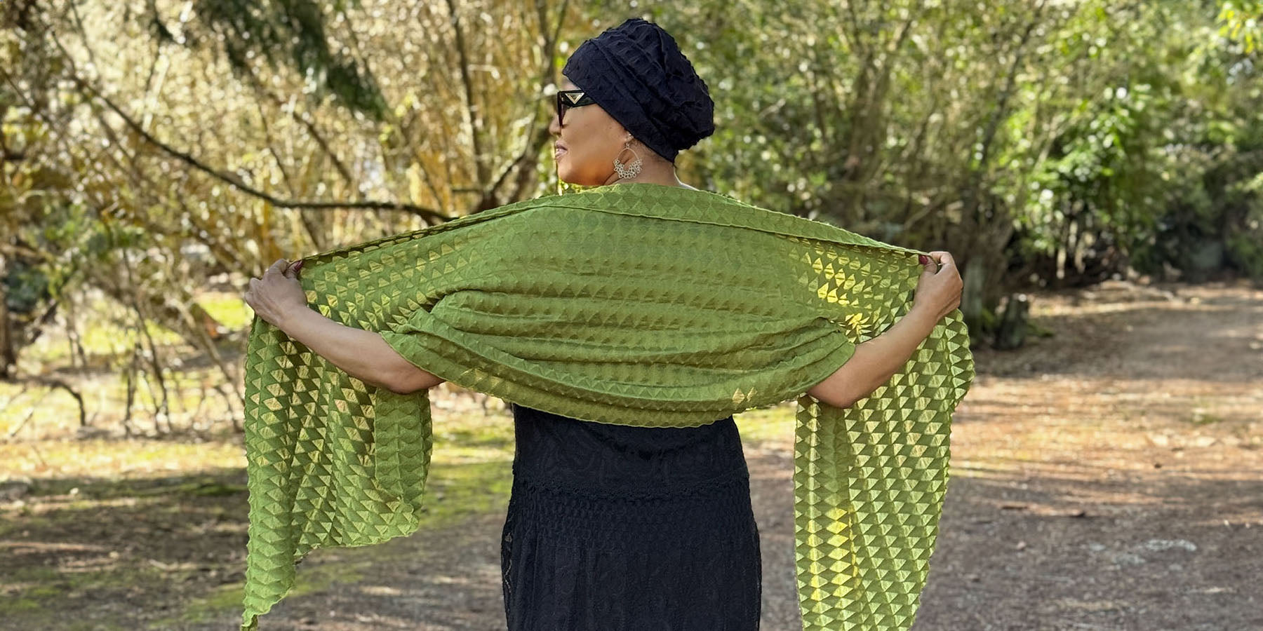 woman holding handkerchief scarf open in sunlight in avocado fractal handmade by Leigh Young Collection