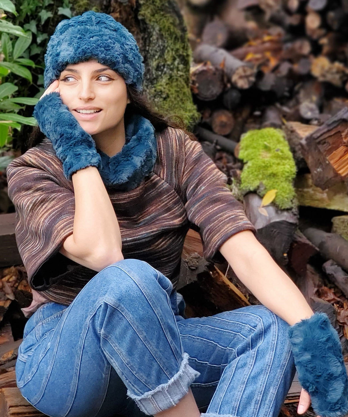 Model Sitting on log wearing Sweater Top | Sweet Stripes in  English Toffee Knit with Peacock Pond Faux Fur Collar | Matching  Headband and Fingerless Gloves in Peacock Pond, Teal Faux Fur Featured | Handmade in the USA by Pandemonium Seattle