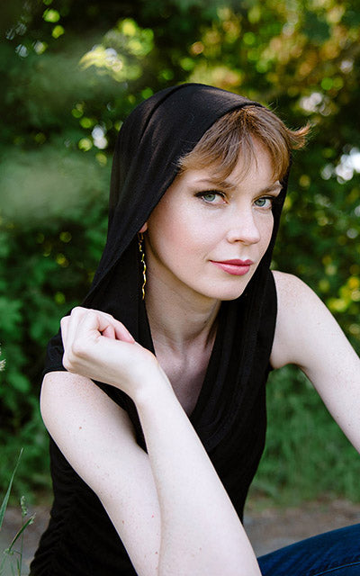 Model wearing the Hooded Cowl Top a This top can be worn as a cowl neck, off-shoulder, or hooded style. | Abyss a alight weight jersey knit in black | Handmade in Seattle WA | Pandemonium Millinery