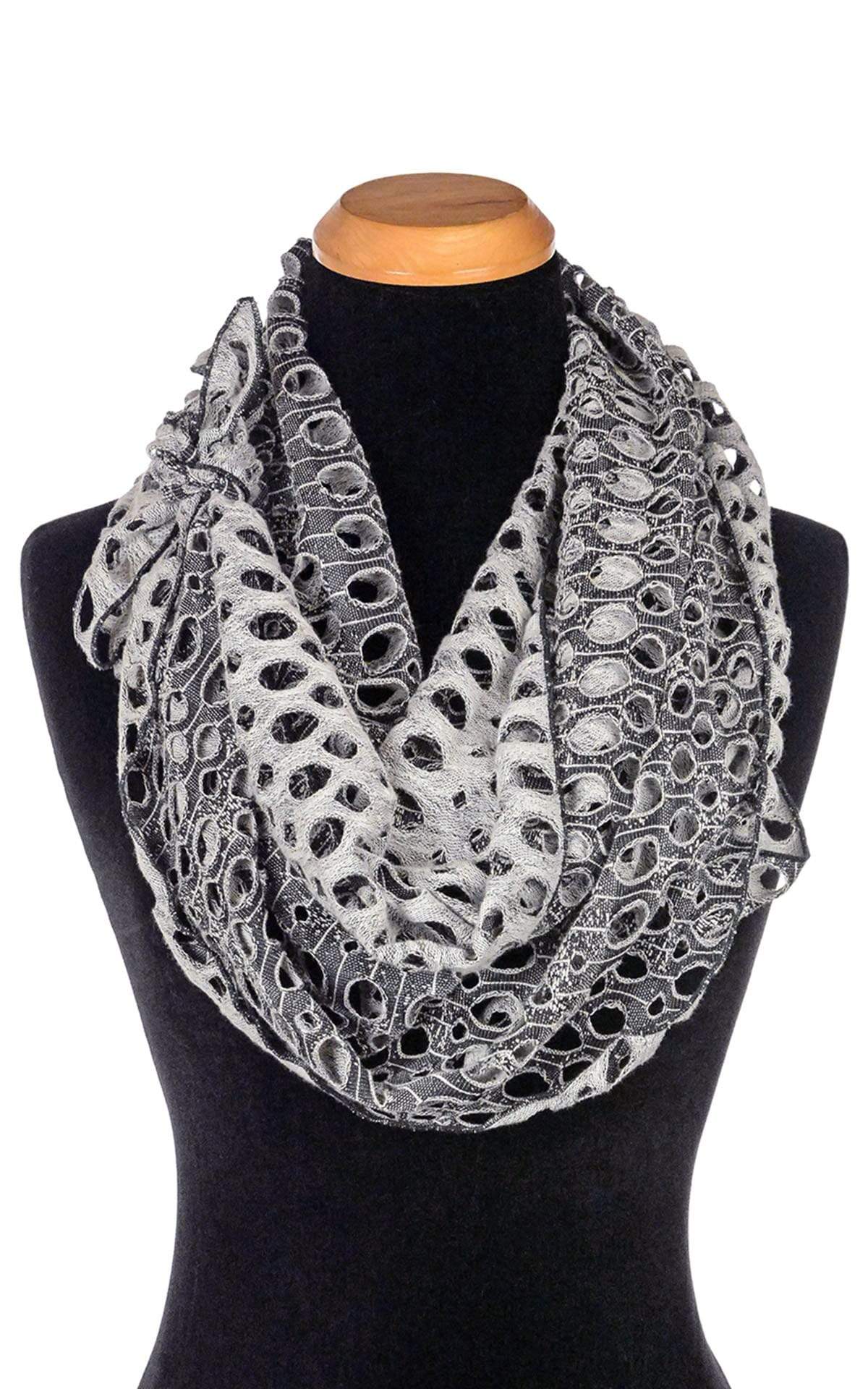 Women’s  Large Handkerchief Scarf, Wrap on Mannequin shown double looped around neck | Lunar Landing, a black and neutral knit with curled edges surrounding holes| Handmade in Seattle WA | Pandemonium Millinery