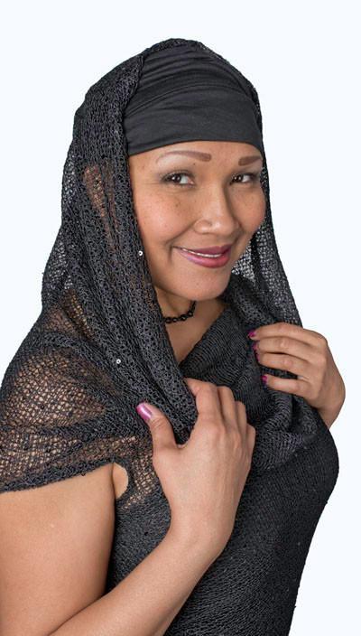 Model wearing the Hooded Cowl Top a This top can be worn as a cowl neck, off-shoulder, or hooded style. | Glitzy Glam in Black, an open weave knit with delicate sequins throughout | Handmade in Seattle WA | Pandemonium Millinery
