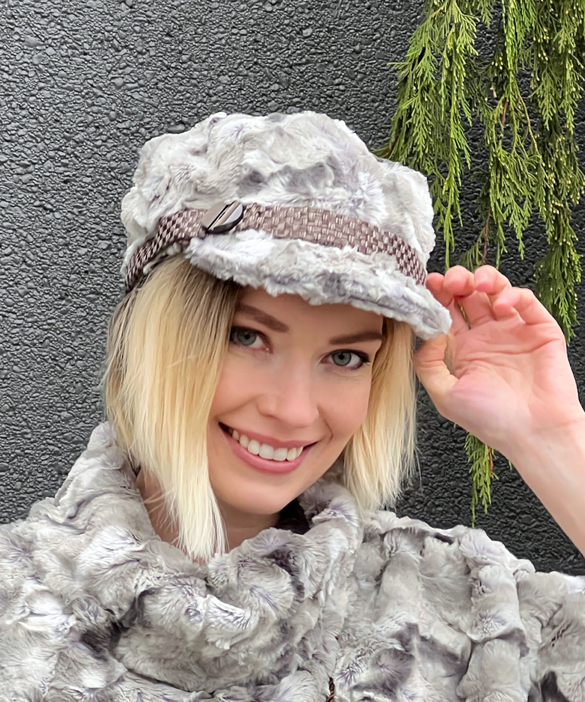 Model waring Valerie Cap in White Water Faux Fur with Interconnected in Java Hat band with  Button trim by Pandemonium Millinery. Handmade in Seattle WA, USA.