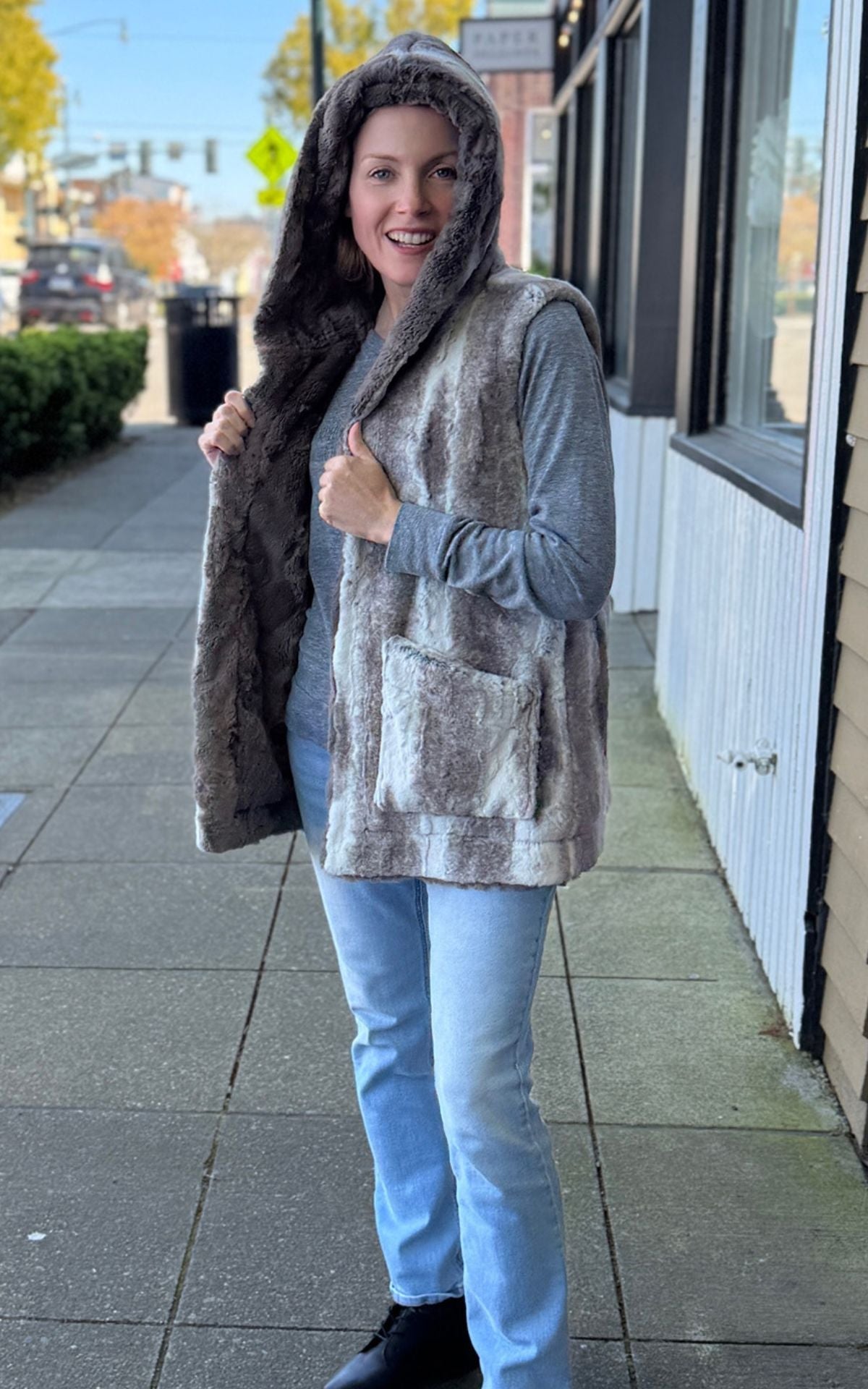 Woman wearing the Oversized Hooded Vest in Driftwood with Taupey Faux Fur.
