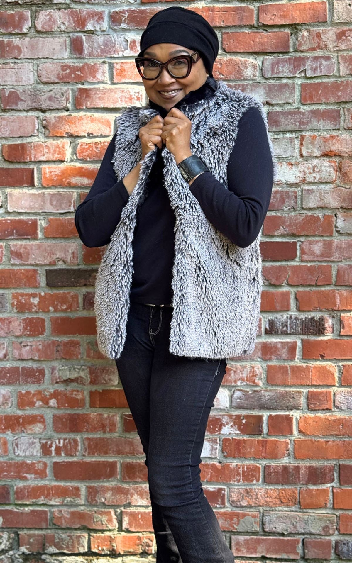 A woman wearing a lightweight printed scarf and linen-style hat against a colorful background.