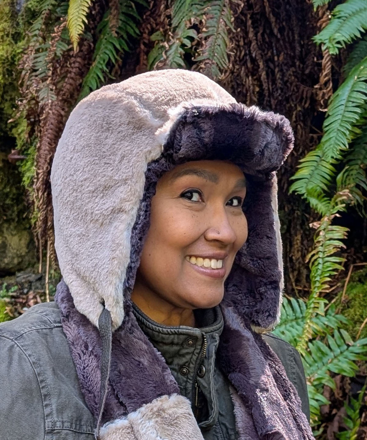 Woman wearing the Aviator Hat in Coastal Plush Golden Bluff lined with Espresso Bean Faux Fur. Shown with the ear flaps down and brim up. Made in Seattle, WA, USA by Pandemonium Seattle.
