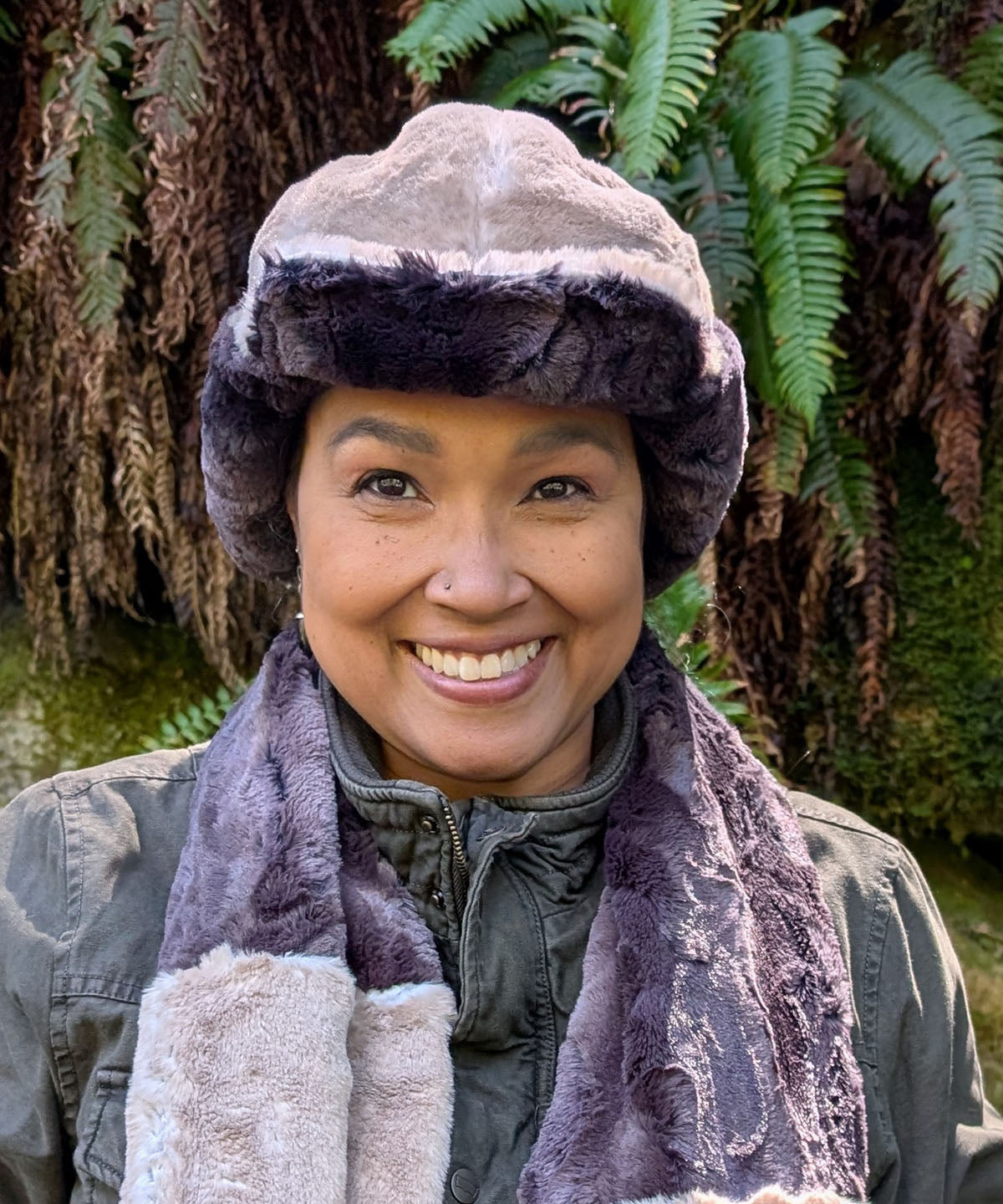 Woman wearing the Aviator Hat in Coastal Plush Golden Bluff lined with Espresso Bean Faux Fur. Shown with the ear flaps buckled up and the brim up. Made in Seattle, WA, USA by Pandemonium Seattle.