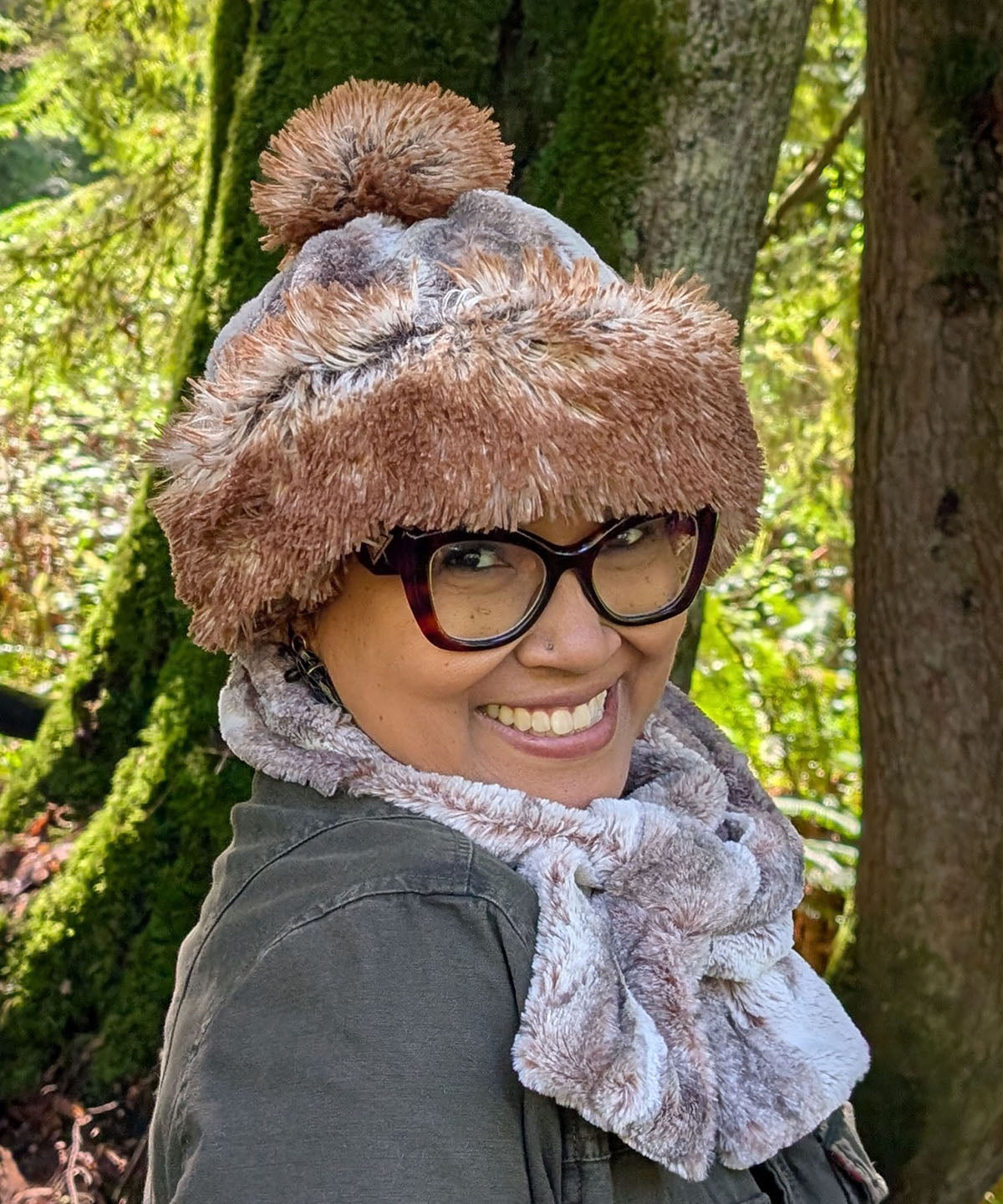 Woman wearing the reversible Beanie in Rusty Rock Faux Fur and Red Fox Faux Fur with a Red Fox Pom. Shown with the Beanie cuffed to show the Red Fox Faux Fur and in profile. Made in Seattle, WA, USA by Pandemonium Seattle.