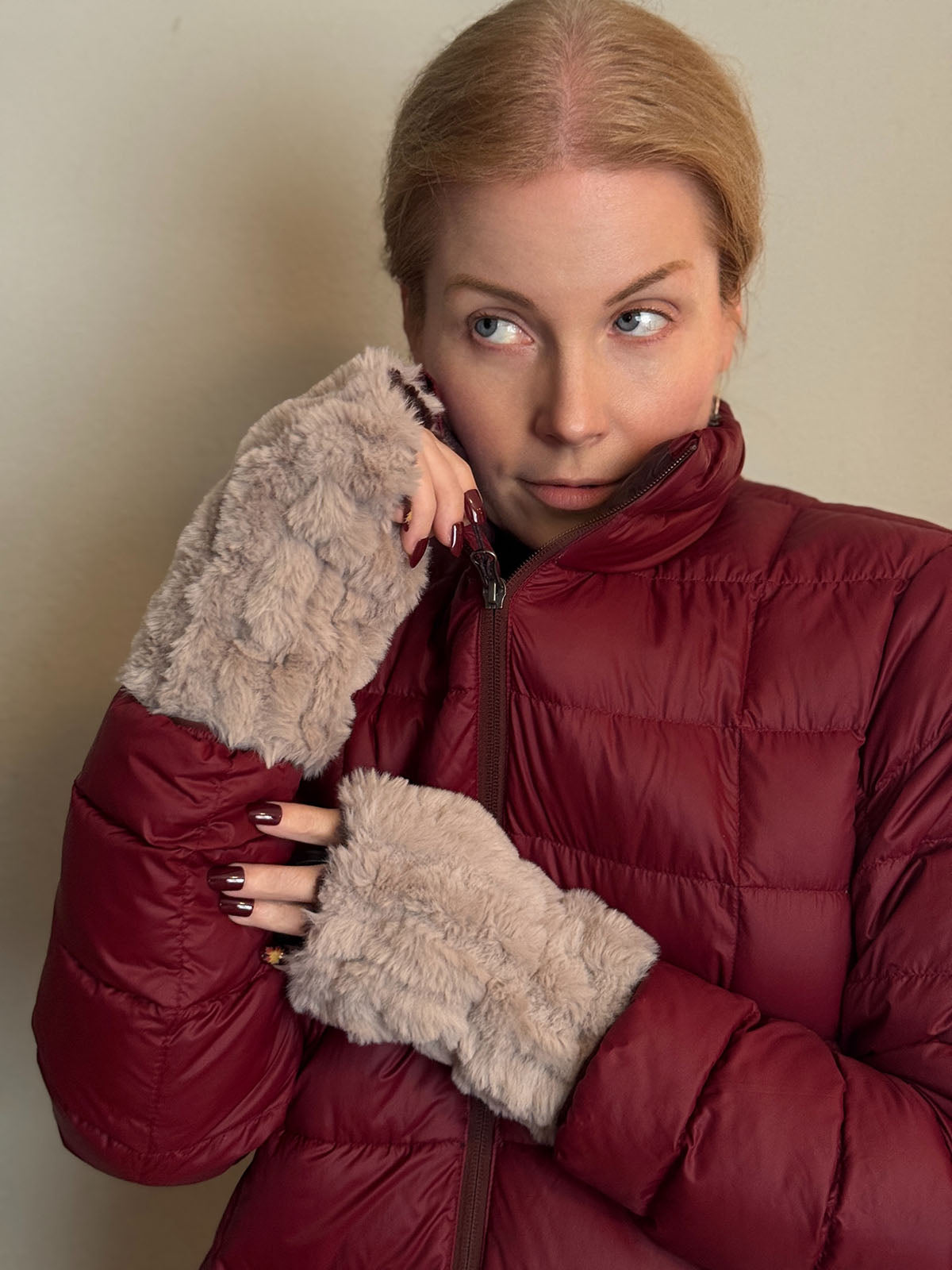 Woman zipping up her puffer coat while wearing Cirrus in Honey Fingerless Gloves. Made in Seattle, WA, USA by Pandemonium Seattle.