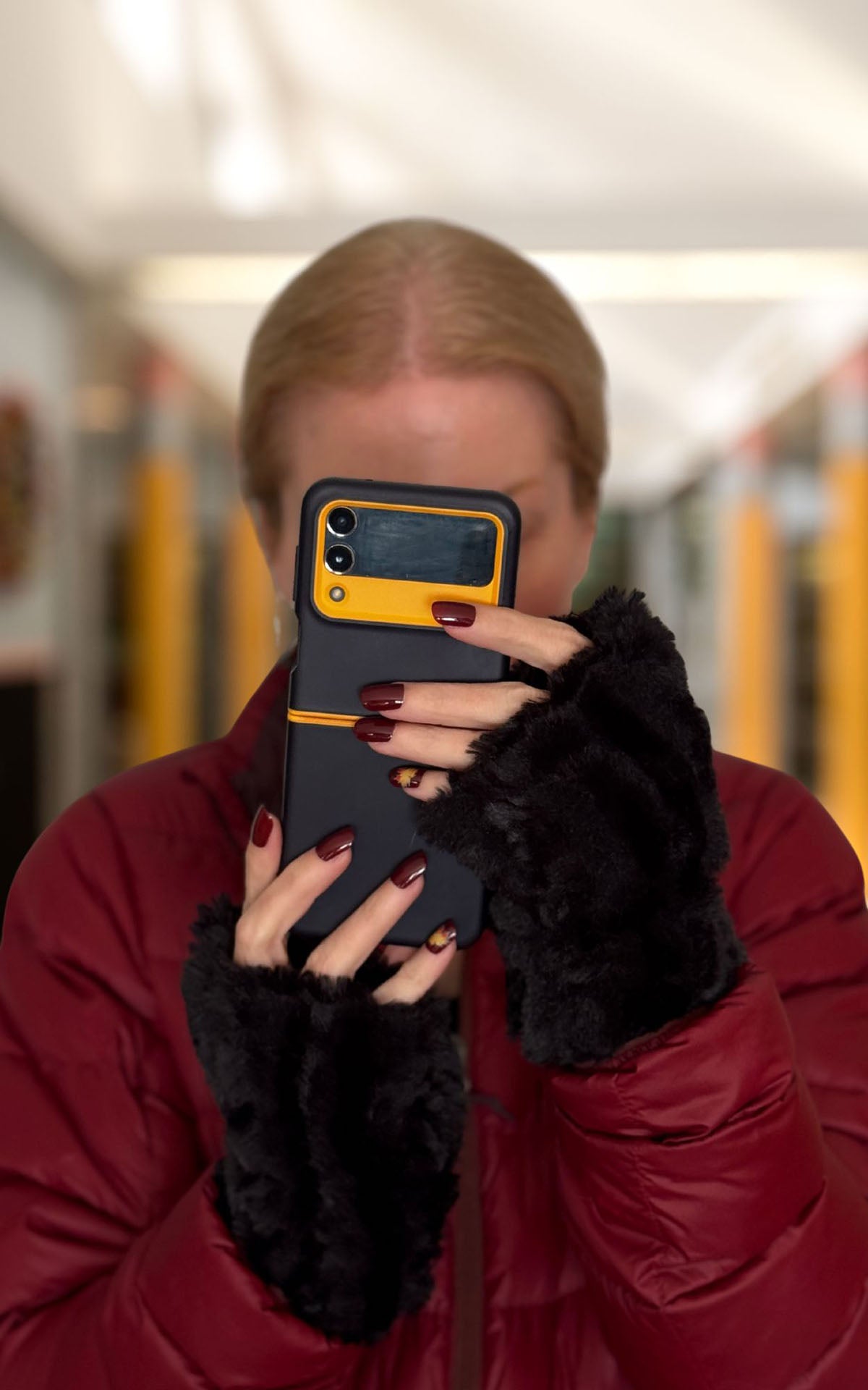Woman wearing Cirrus in Shadow black Fingerless Gloves while using a cell phone. Made in Seattle, WA, USA by Pandemonium Seattle.