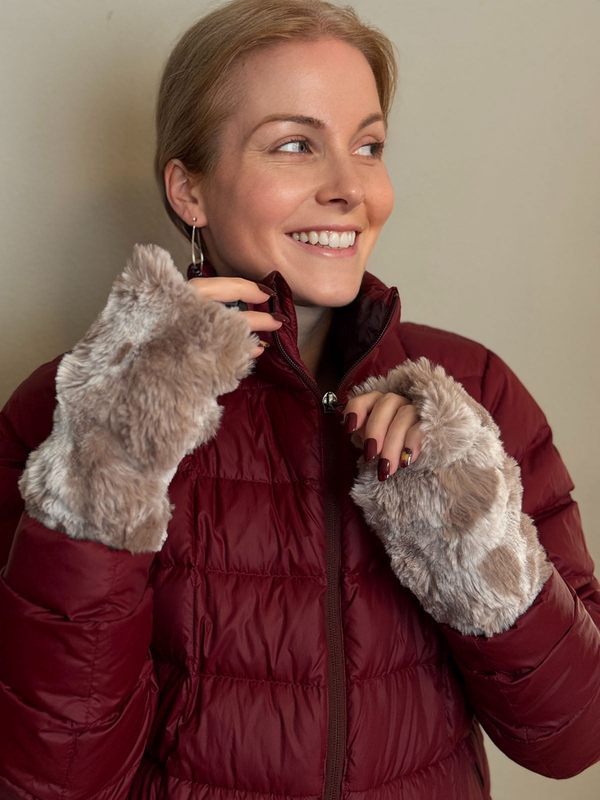 Woman wearing a puffer jacket and holding the zipper with Cloudwalk Honey Fingerless Gloves. Made in Seatte, WA, USA by Pandemonium Seattle.