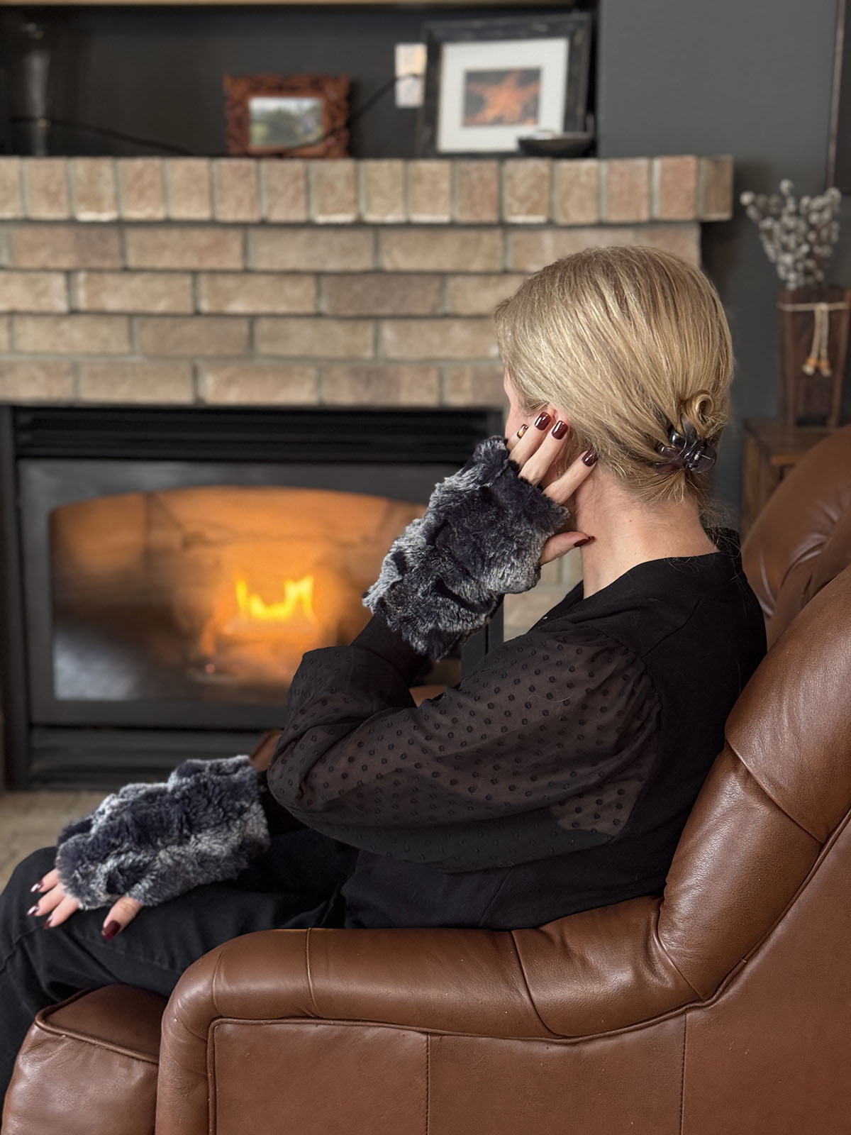 Woman wearing Cloudwalk Shadow Fingerless Gloves sitting by the fire. Made in Seattle, WA, USA by Pandemonium Seattle.