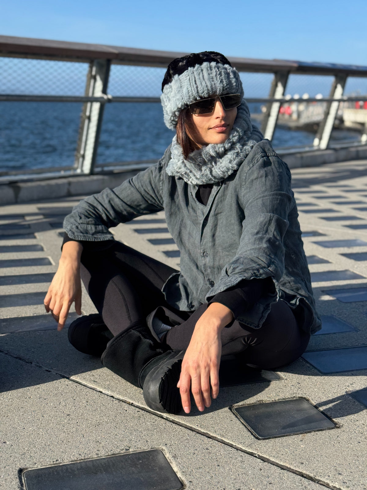 Woman wearing the Cuffed Pillbox in Cirrus Blue Mist with Cuddly Black. Shown reversed to black with Cirrus Blue Mist cuffed. Also wearing a matching Cirrus Blue Mist Neck Warmer. Handmade in Seattle, WA, USA by Pandemonium Millinery.