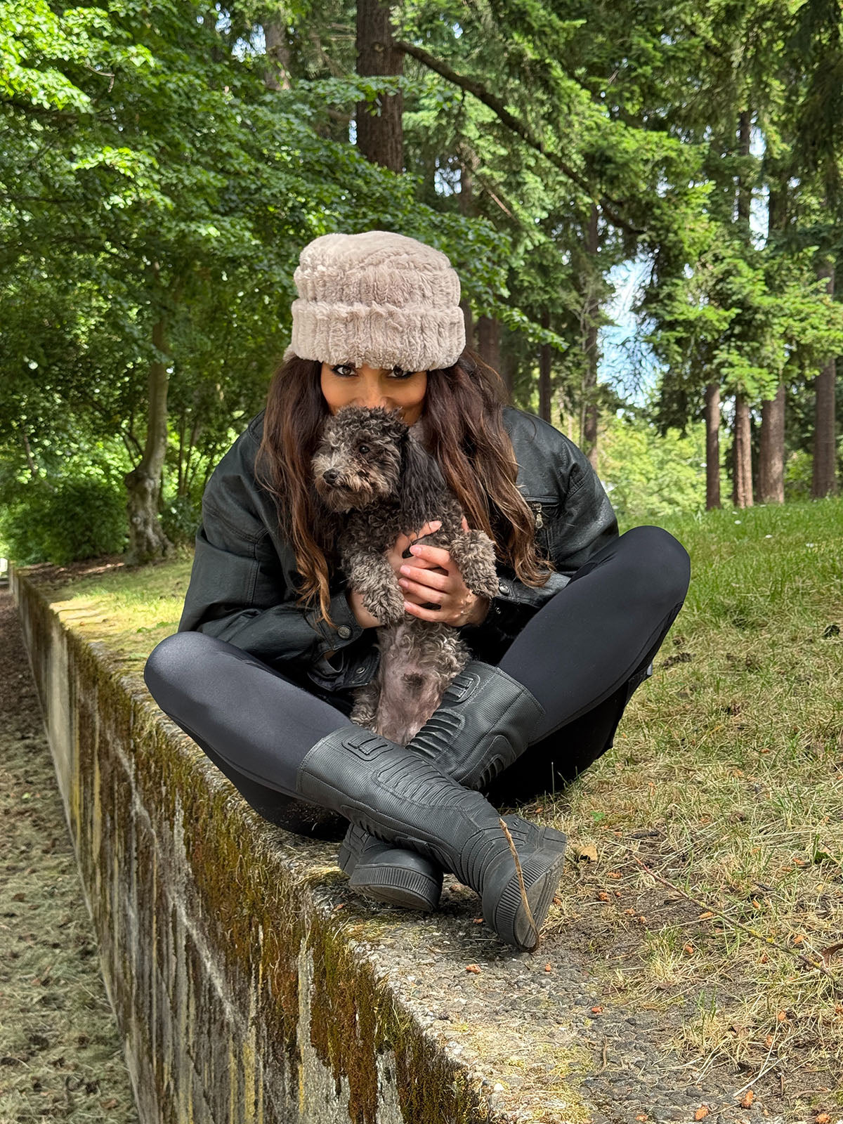 Woman wearing the Cuffed Pillbox in Cirrus Honey and holding a puppy. Hand sewn in Seattle, WA by Pandemonium Seattle.