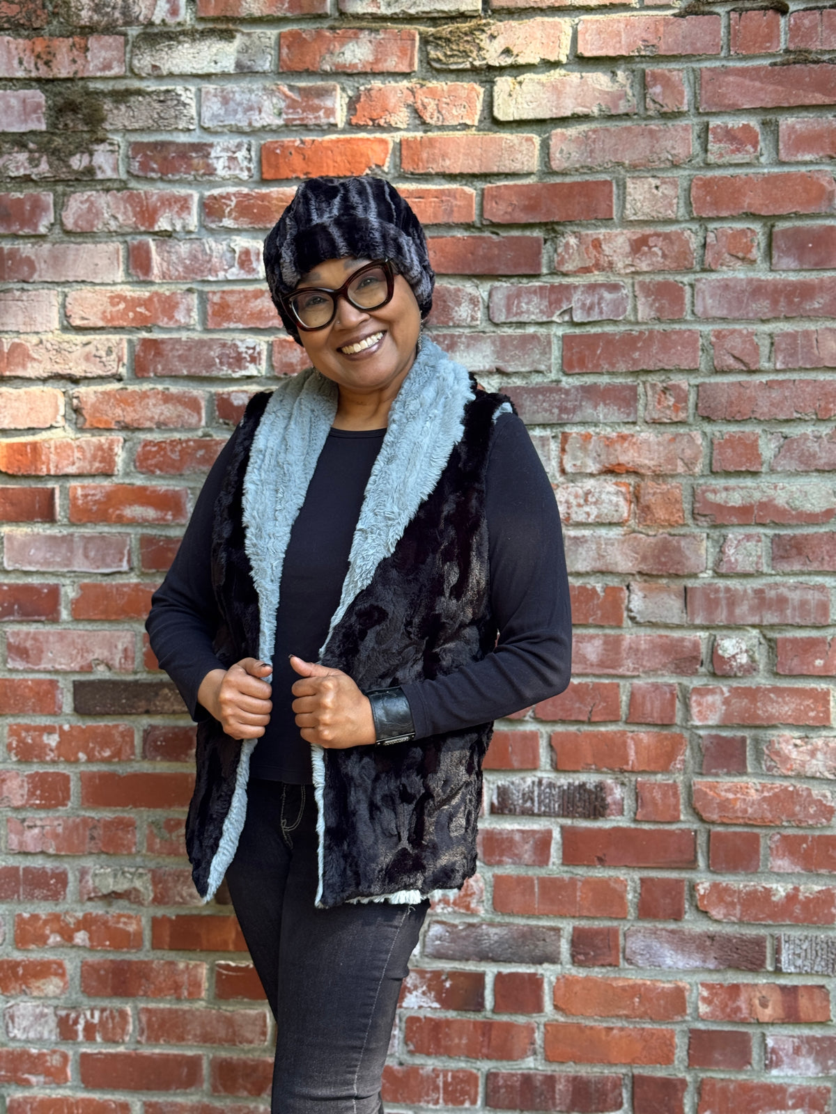 Woman wearing the Shawl Collar Vest in Cirrus Blue Mist with reversible Cuddly Black faux fur. Reversed to show Cuddly Black with Cirrus Blue Mist as option.
 Hand sewn in Seattle, Washington by Pandemonium Seattle.