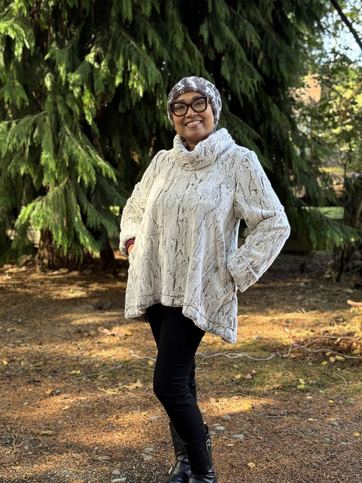 Woman wearing the Cowl Top Pullover in Khaki, with her hands in the pockets. Also wearing a Cuffed Pillbox in Marble Dune Grey. Made in Seattle, WA, USA by Pandemonium Seattle.
