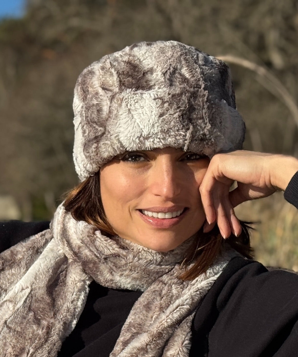 Woman wearing a Cuffed pillbox in Rusty Rock Faux Fur with a matching scarf in a natural setting. Handsewn by Pandemonium Millinery. Seattle WA USA