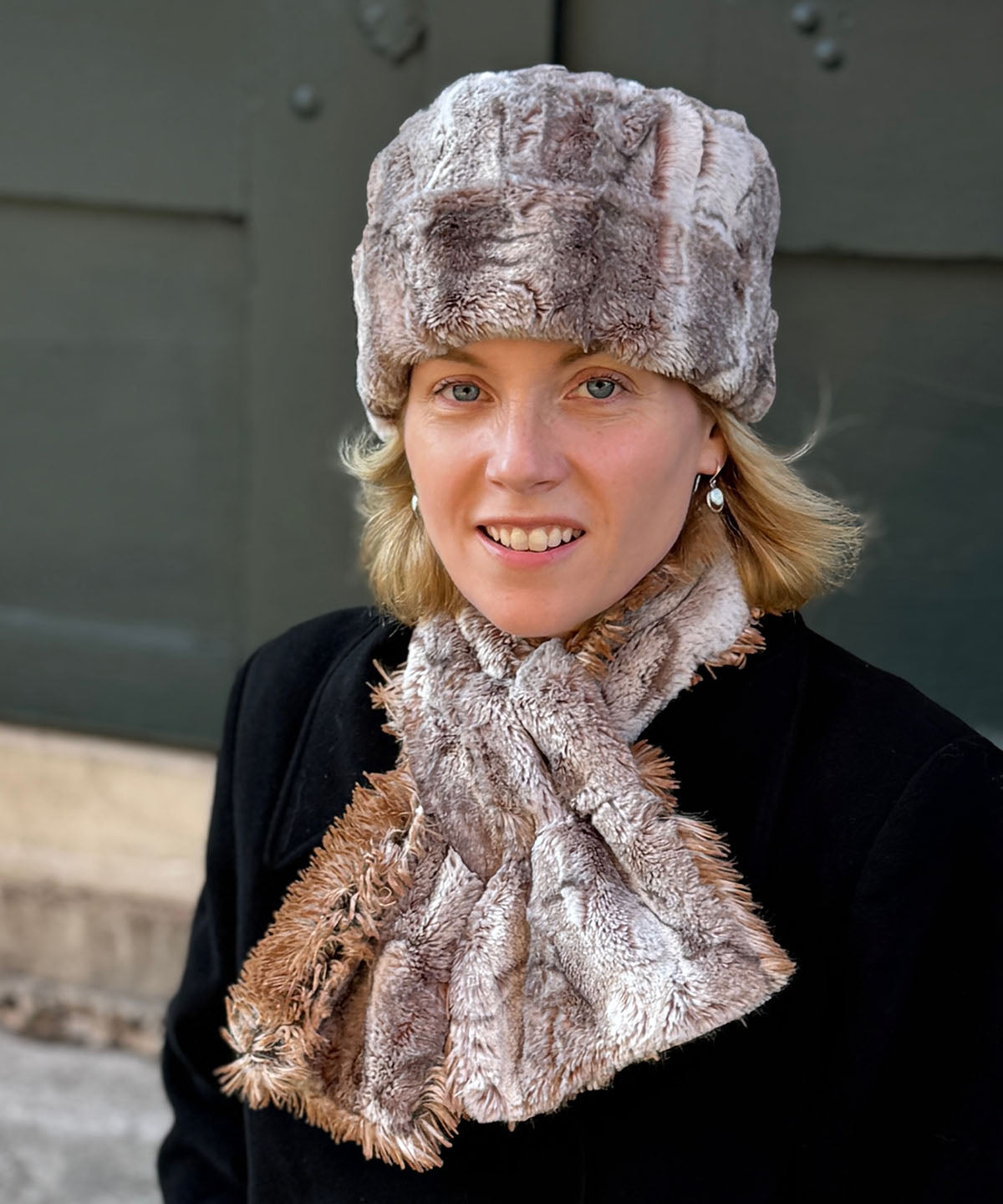 A woman wearing the Cuffed Pillbox in Rusty Rock Faux Fur with the cuff rolled up. Also, wearing a matching Pull-Thru Scarf in Rusty Rock with Red Fox Faux Fur. Made in Seattle, WA, USA by Pandemonium Seattle.