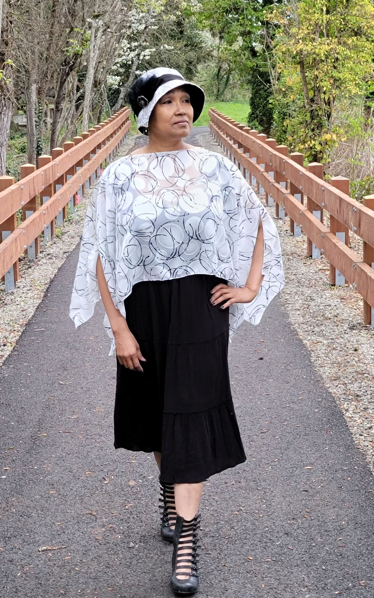 Woman wearing the Lumina Poncho in Ditzy Dame, shown in boat neck styling. Made in Seattle, WA, USA by Pandemonium Seattle.