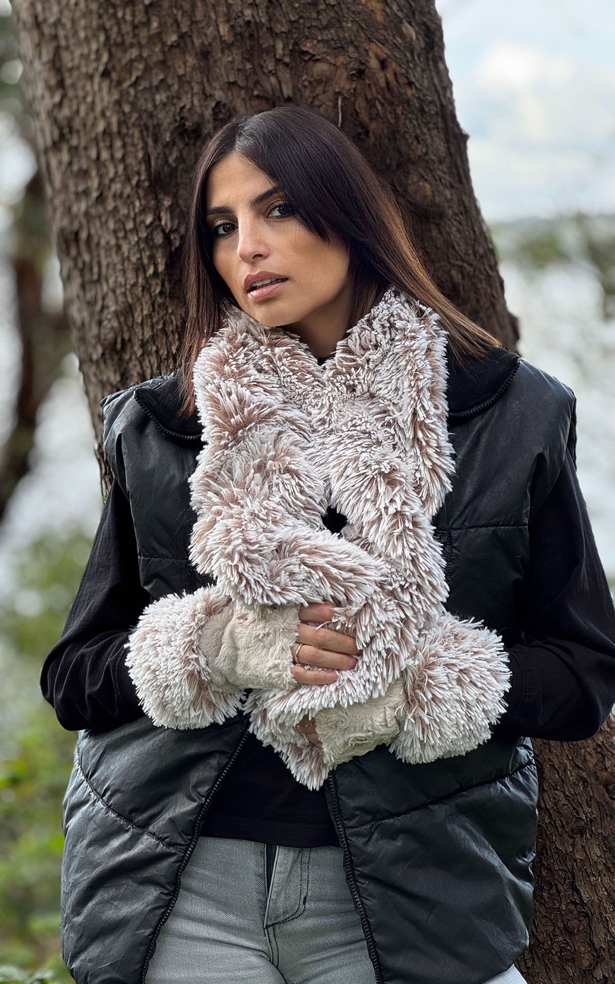 A woman standing in front of a tree wearing a Scrunchy Scarf in Foxy Beach Faux Fur. Handmade in Seattle, WA , USA by Pandemonium Millinery