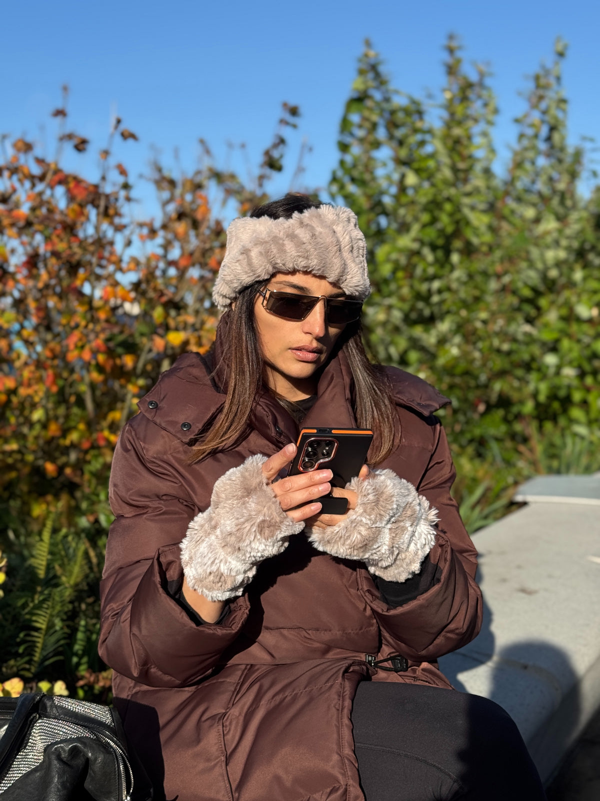 Woman wearing Fingerless Gloves in Cloudwalk Honey and a Cirrus Honey Headband while texting. Handmade in Seattle, WA, USA by Pandemonium Millinery.