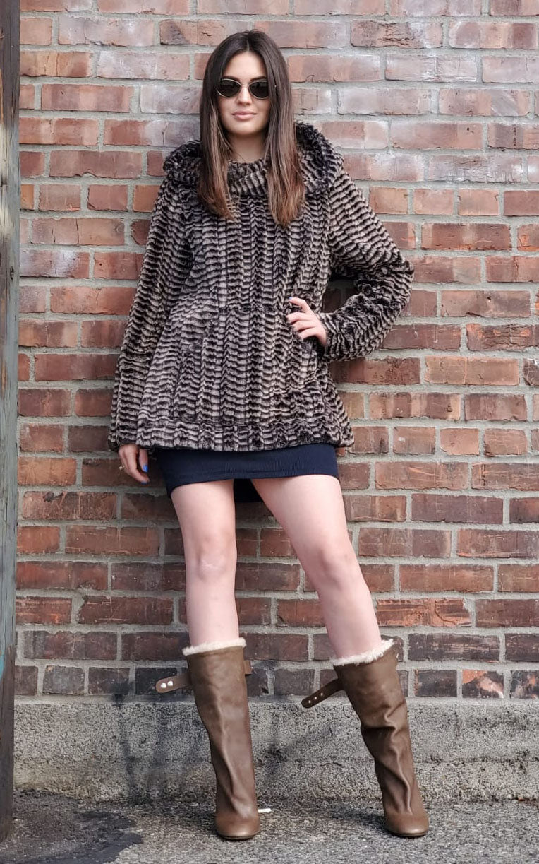 Woman Standing against brick wall wearing a Hooded Lounger | Luxury Faux Fur 8mm in Sepia |  Handmade by Pandemonium Millinery | Seattle WA USA