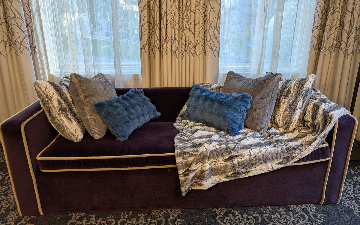 Sofa shown with the Smoke Show Faux Fur Throw Blanket across the sofa arm. Also shown with matching and complemetary throw pillows in faux fur. Made in Seattle, WA, USA by Pandemonium Seattle.