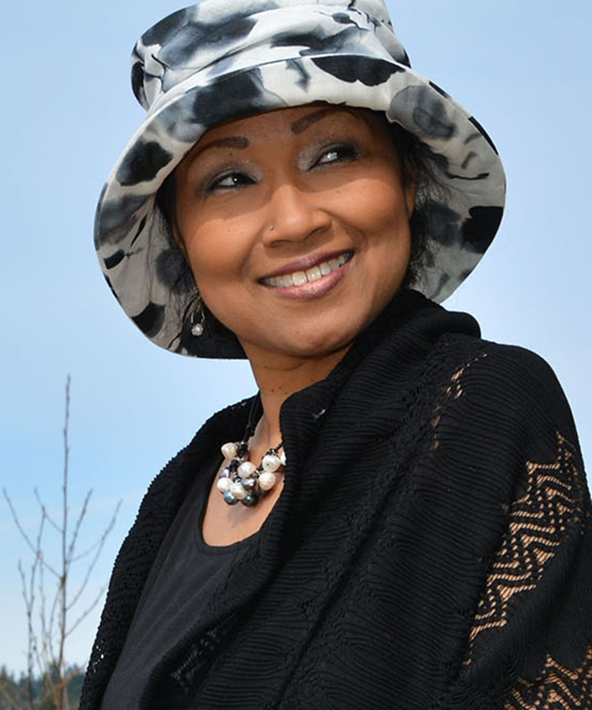woman wearing matching bag with Krystyne Bucket Hat in Black and White Floral Linen Handmade in Seattle WA by Pandemonium Millinery USA