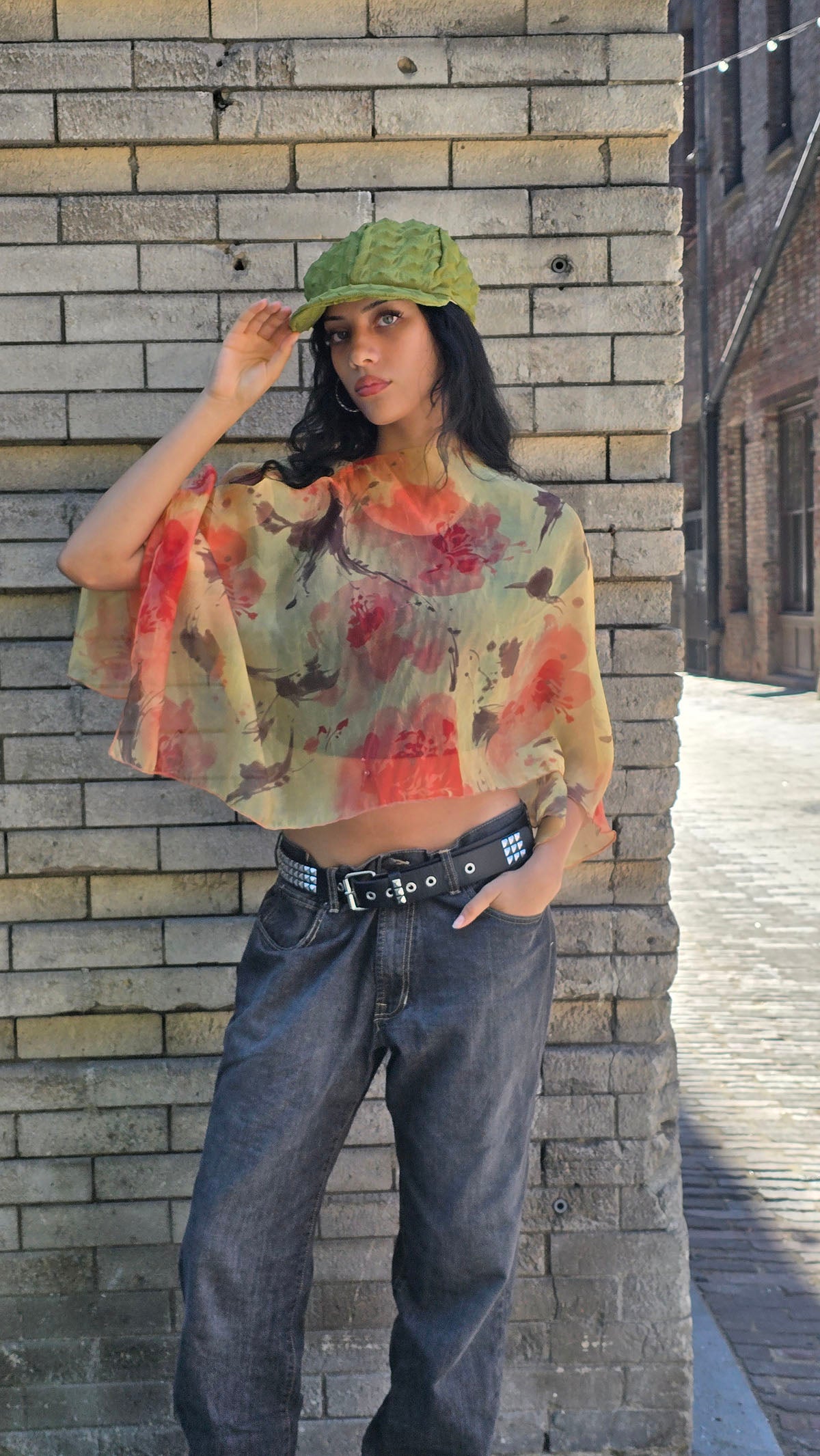 Woman wearing the Sun Star Coastal Garden Poncho with jeans. Also wearing the LYC Dianne Cap in Avocado. Made in Seattle, WA, USA by Pandemonium Seattle.