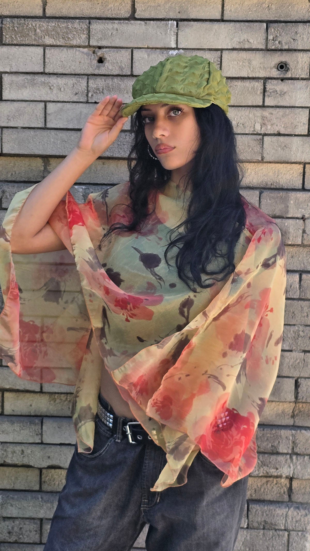 Closer view of woman wearing the Sun Star Coastal Garden Poncho. Also wearing the LYC Dianne Cap in Avocado. Made in Seattle, WA, USA by Pandemonium Seattle.