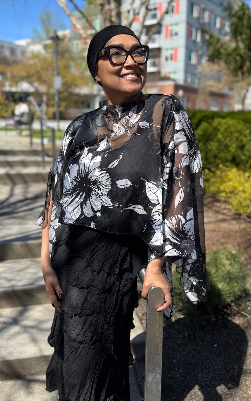 Woman wearing the Lumina Poncho in Leading Lady, shown in boat neck styling. Made in Seattle, WA, USA by Pandemonium Seattle.
