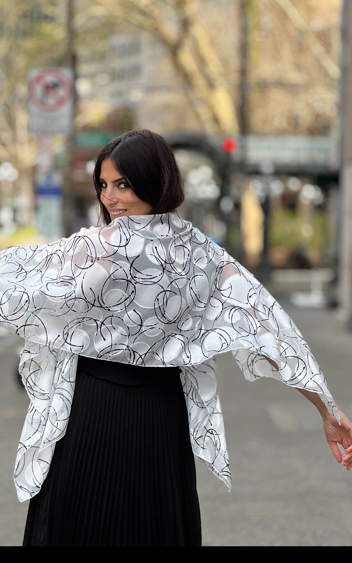 Back view of a model  wearing Lumina Poncho in Ditsy Dame. Handsmade in Seattle, WA, USA by Pandemonium Seattle