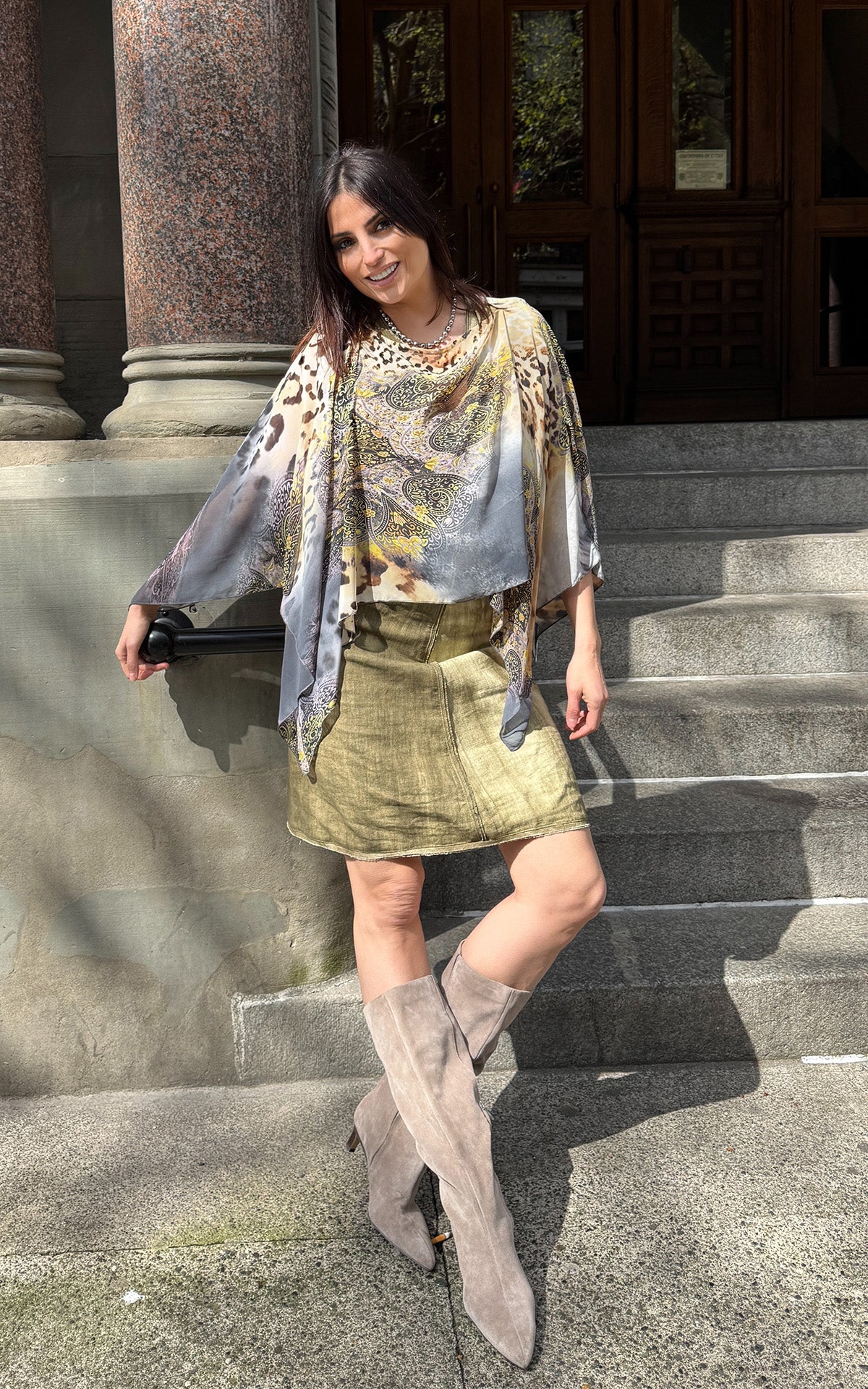 Woman wearing the Lumina Poncho in Ditzy Dame, shown in boat neck styling. Made in Seattle, WA, USA by Pandemonium Seattle.