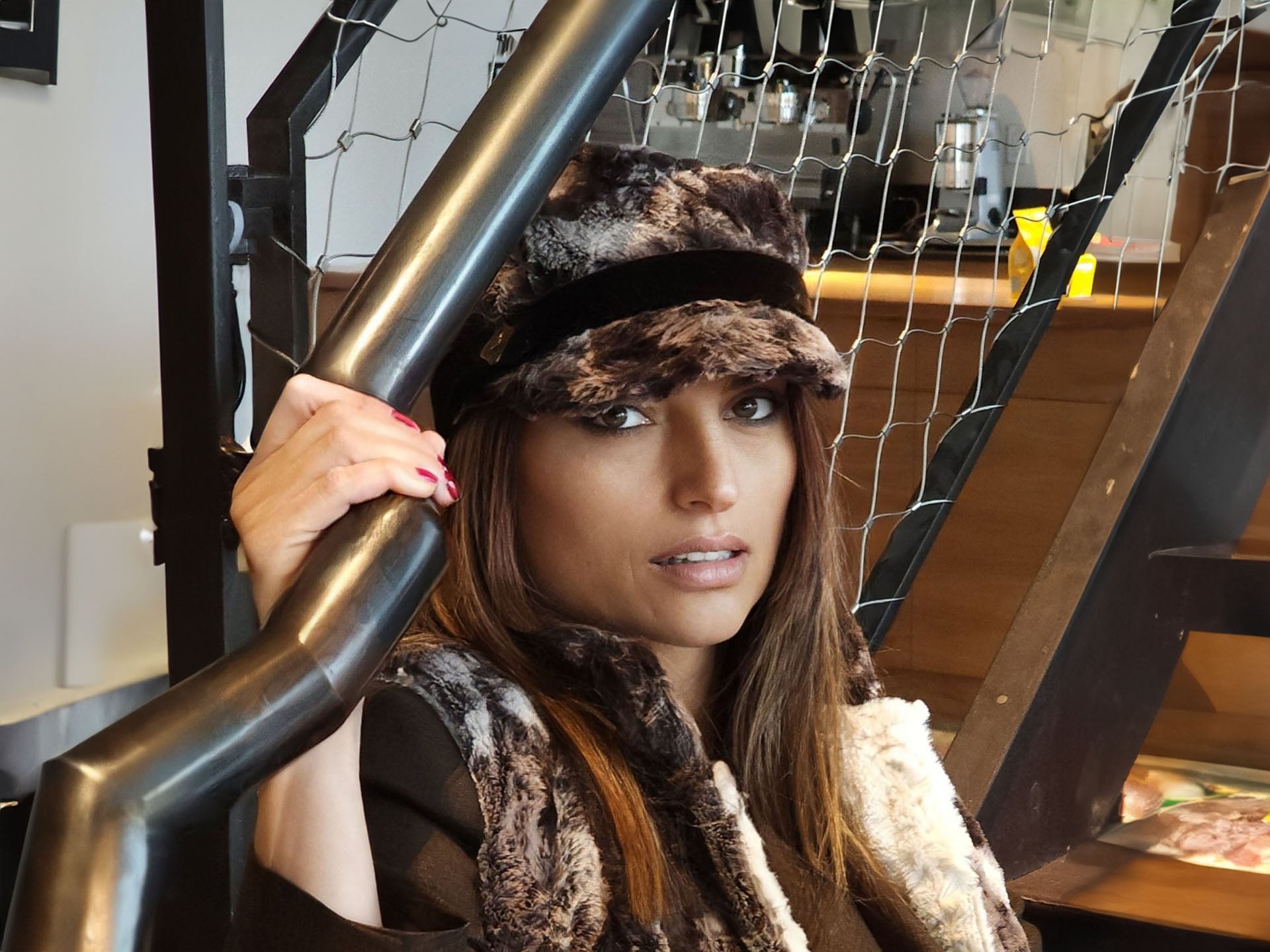 woman sitting on stairs wearing a brown faux fur hat and matching vest handmade in America by Pandemonium Seattle