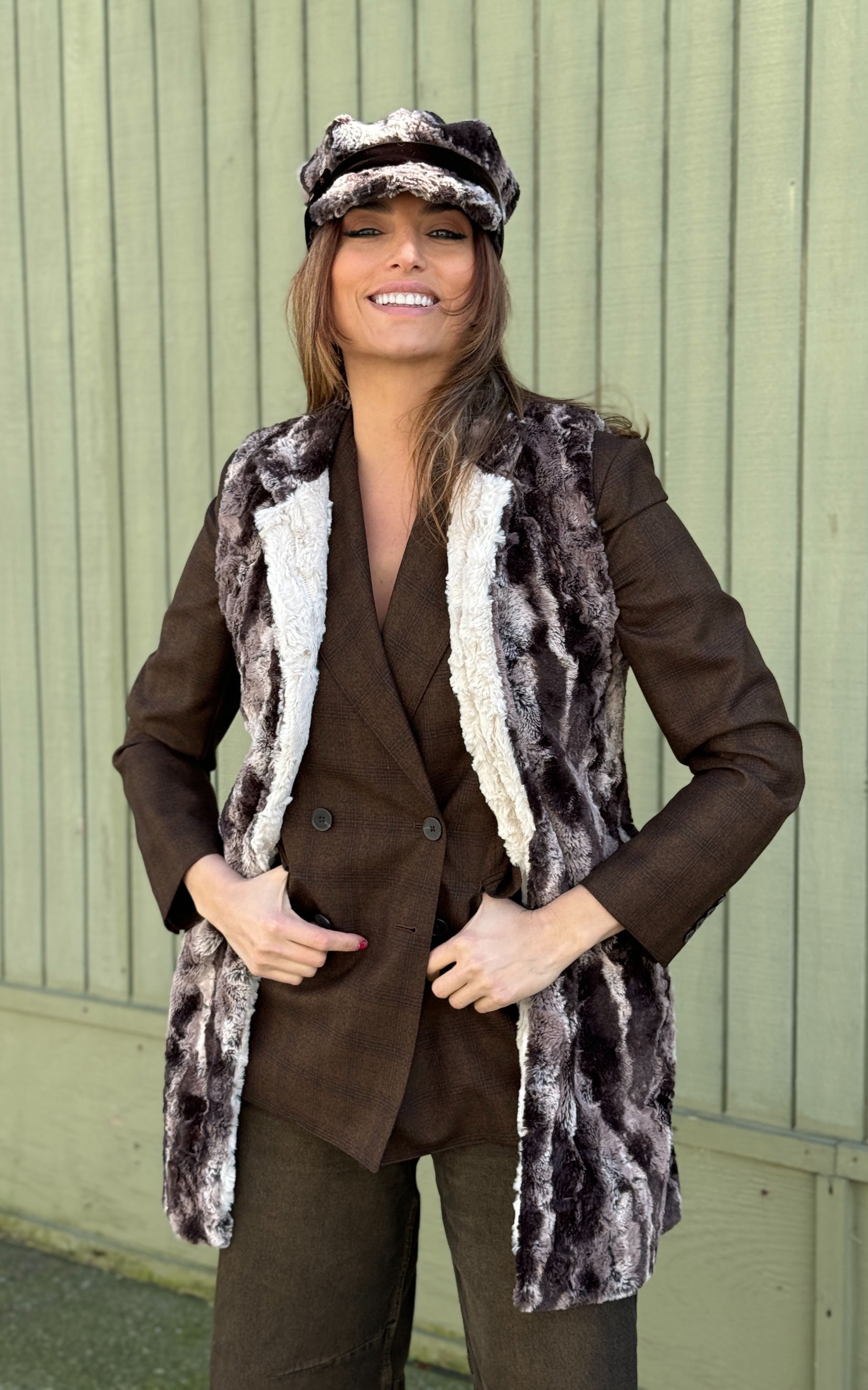 Model against green wall wearing a matching Newsboy Hat and Mandarin Vest - Luxury Faux Fur in Mocha with a Cuddly Sand Lining - Handmade USA by Pandemonium Seattle