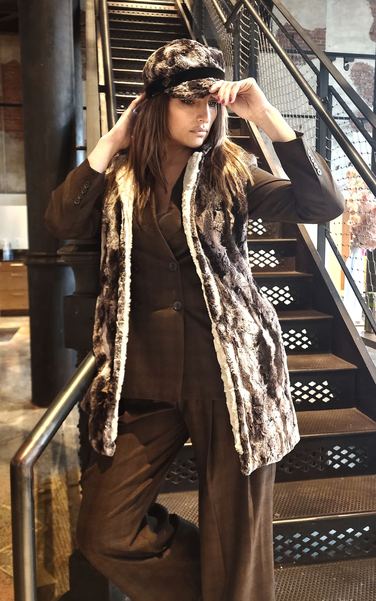 Model on stairs wearing a matching Newsboy Hat and Mandarin Vest - Luxury Faux Fur in Mocha with a Cuddly Sand Lining - Handmade USA by Pandemonium Seattle