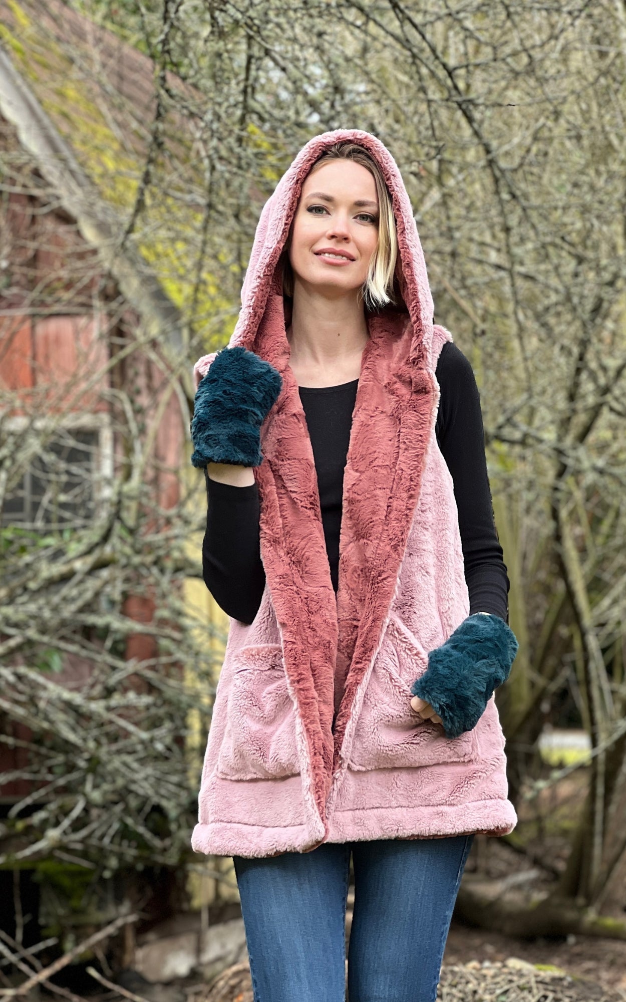 Woman wearing the Oversized Hooded Vest in Frosted Cedar with the reverse color Copper River faux furs. Also wearing faux fur fingerless gloves in Peacock Pond. Handmade in Pandemonium Seattle.
