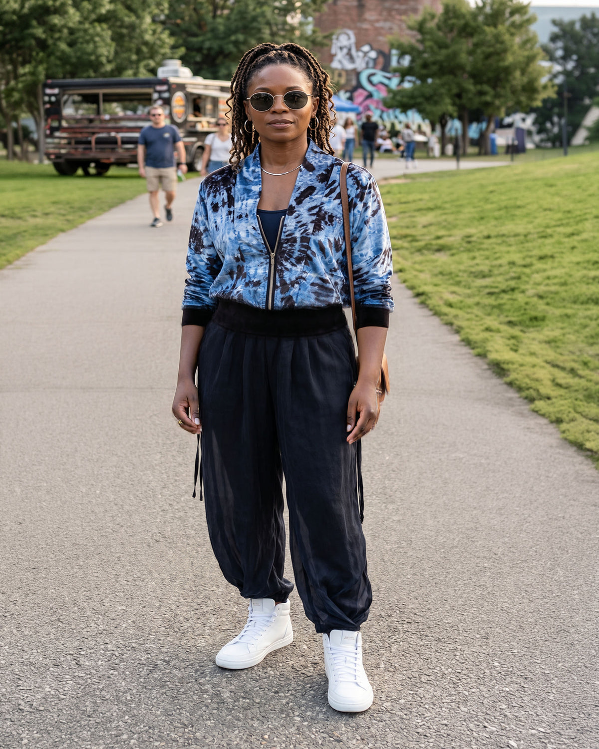 A woman wearing the Pleated Ankle Jogger Pants in Inkwell navy blue with the Zipper Jacket Top in Mirage. Made in Seattle, WA, USA by Pandemonium Seattle.