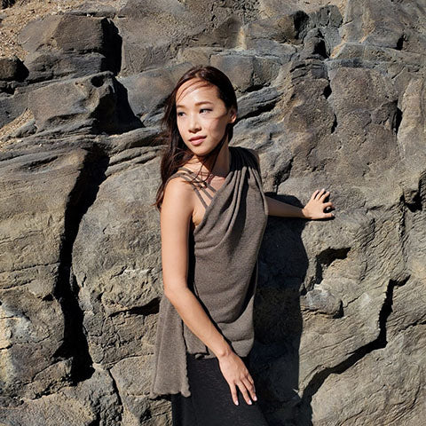 woman by rock wall wearing unique crepe top by Leigh Young Collection Seattle WA