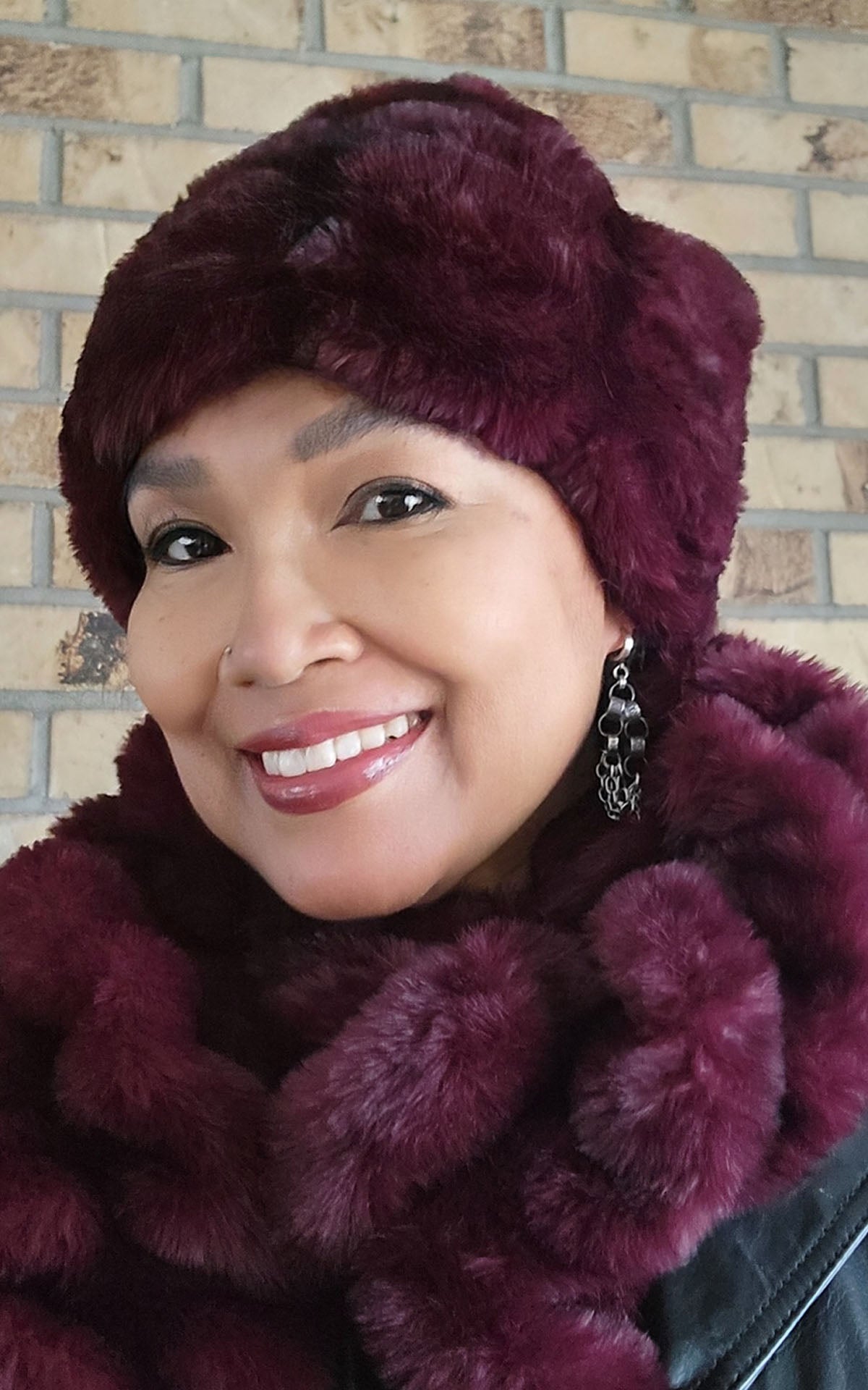 A woman wearing the Royal Opulence Pull-Thru Scarf in Cherry Bomb with the matching Beanie Hat. Made in Seattle, WA, USA by Pandemonium Seattle.