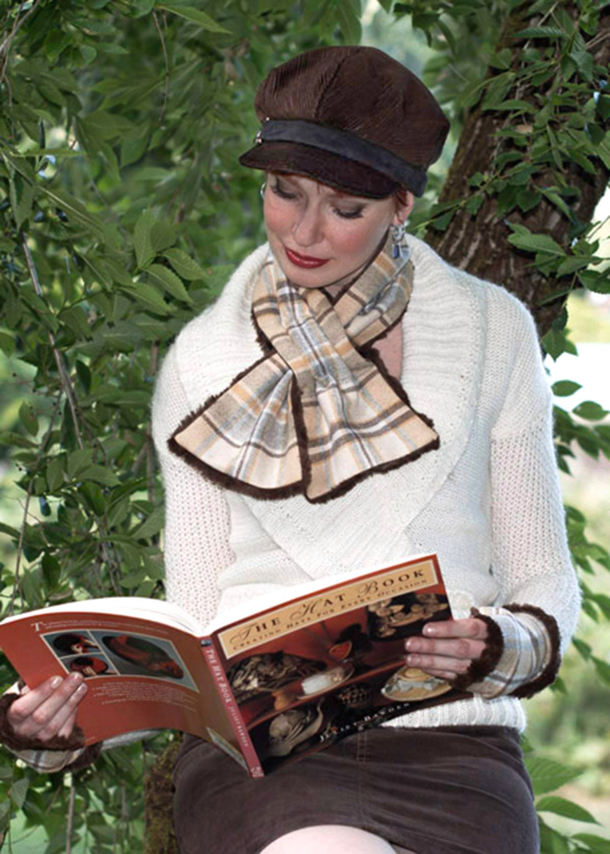 Women sitting in tree reading a book wearing a Valerie cap style hat and a  reversible Pull Through Scarf | Wool Plaid in Day Break, yellow cream brown, and blue  with Cuddly Faux Fur in chocolate | Handmade in Seattle WA | Pandemonium Millinery