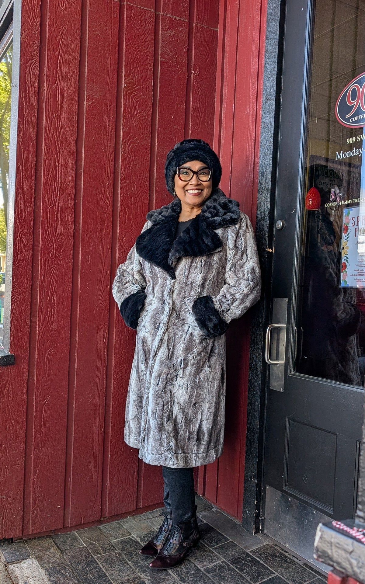 Woman wearing the Roxy Coat in Rock Steady Faux Fur with Onyx Faux Fur  collar and cuffs.  Handmade in Seattle WA, USA by Pandemonium Seattle