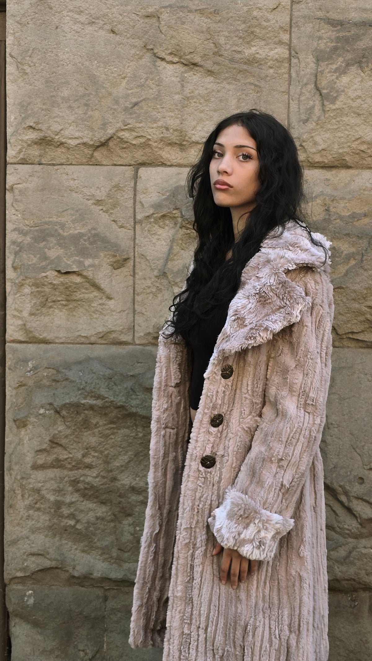 Woman in side profile, wearing the Roxy Coat in Cirrus in Honey and Cloudwalk Honey Cuffs and Collar. Made in Seattle, WA, USA by Pandemonium Seattle.