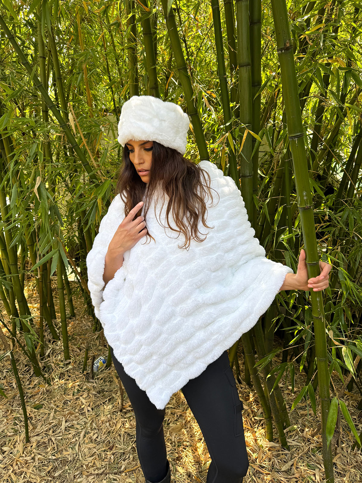 Woman wearing the Royal Opulence Poncho in Heavenly faux fur and glancing down. Hand sewn in Seattle, Washington by Pandemonium Seattle.