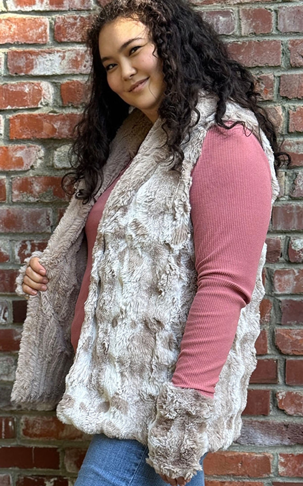 Woman wearing the Shawl Collar Vest in Cloudwalk Honey with reversible Cirrus Honey faux furs. Side view to display the reversible side. Hand sewn in Seattle, Washington by Pandemonium Seattle.