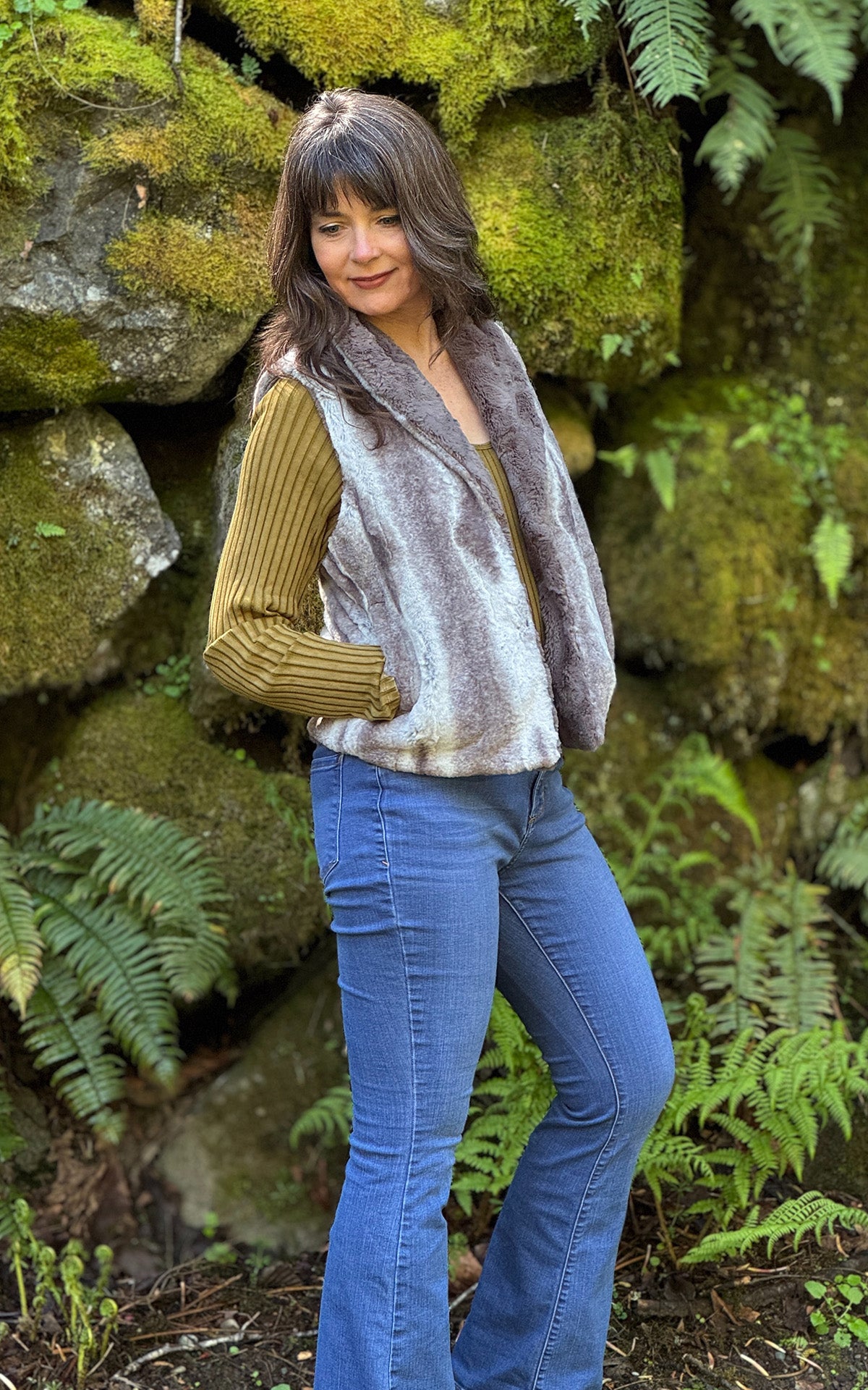 Woman wearing the Shawl Collar Vest in Driftwood Luxury Faux Fur with reversible Cuddly Taupey Faux Fur, with her hands in the side pockets. Made in Seattle, WA, USA by Pandemonium Seattle.