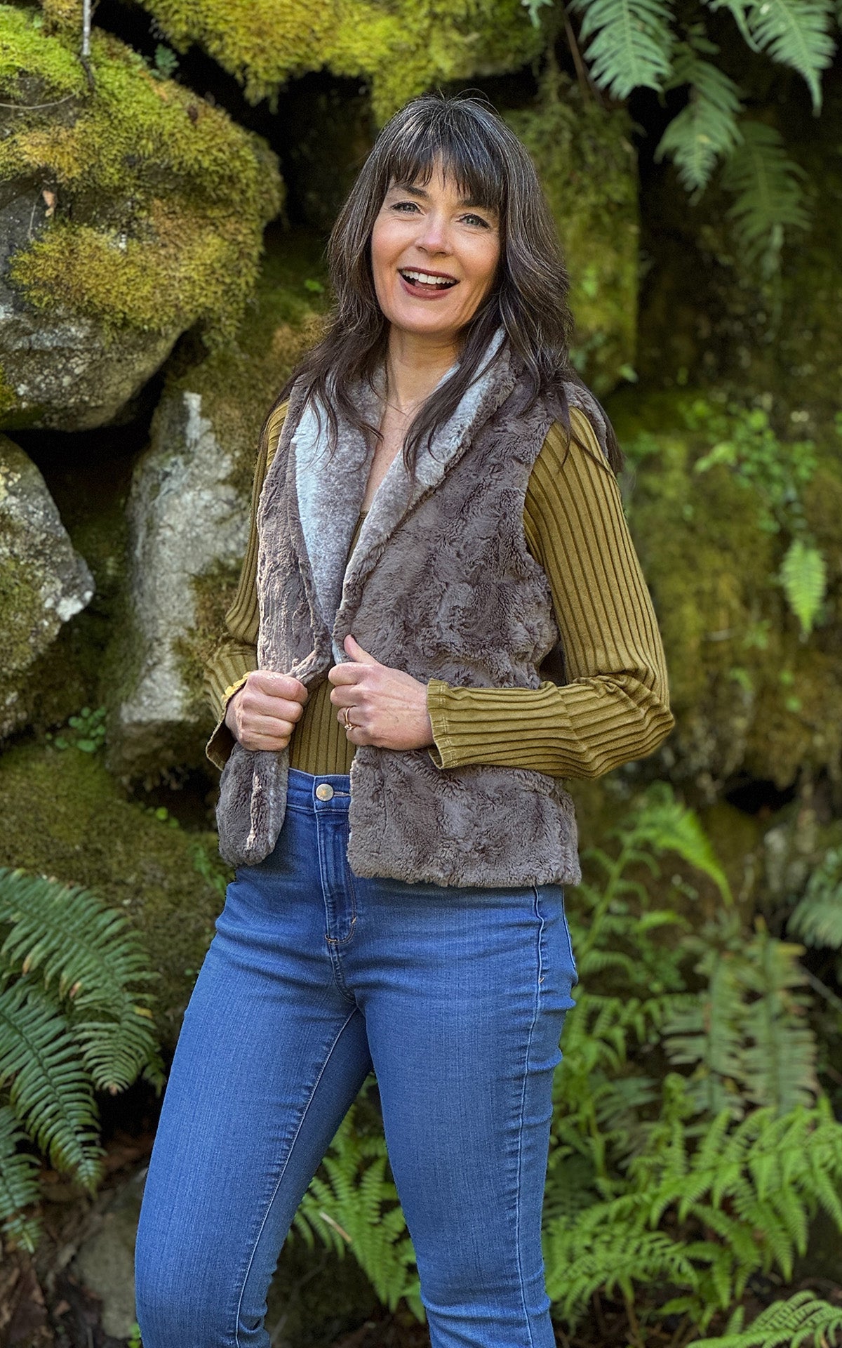 Woman wearing the Shawl Collar Vest in Driftwood Luxury Faux Fur with reversible Cuddly Taupey Faux Fur. Shown reversed with the Taupey Faux Fur side and Driftwood Collar. Made in Seattle, WA, USA by Pandemonium Seattle.