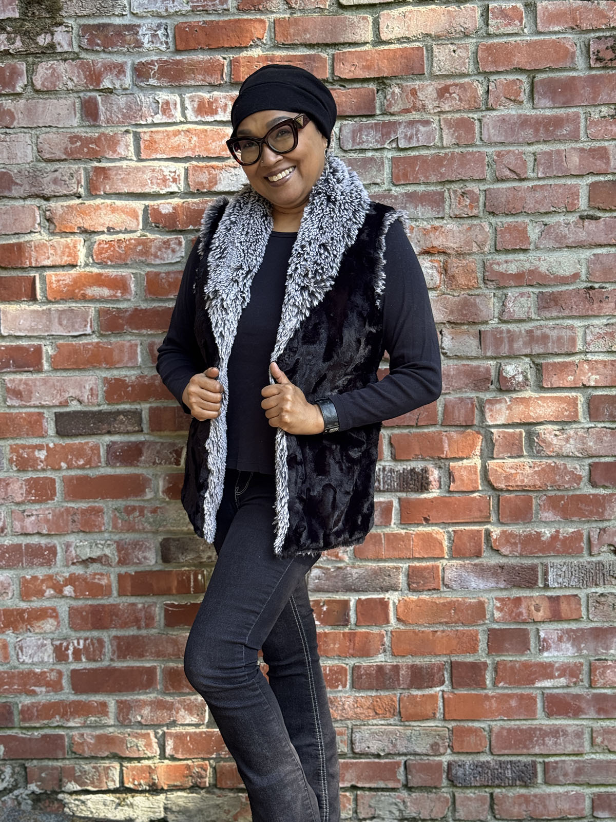 Woman wearing the Shawl Collar Vest in Cuddly Black and Silver Tipped Fox in Black, side view. Handmade in Seattle, WA, USA by Pandemonium Millinery.