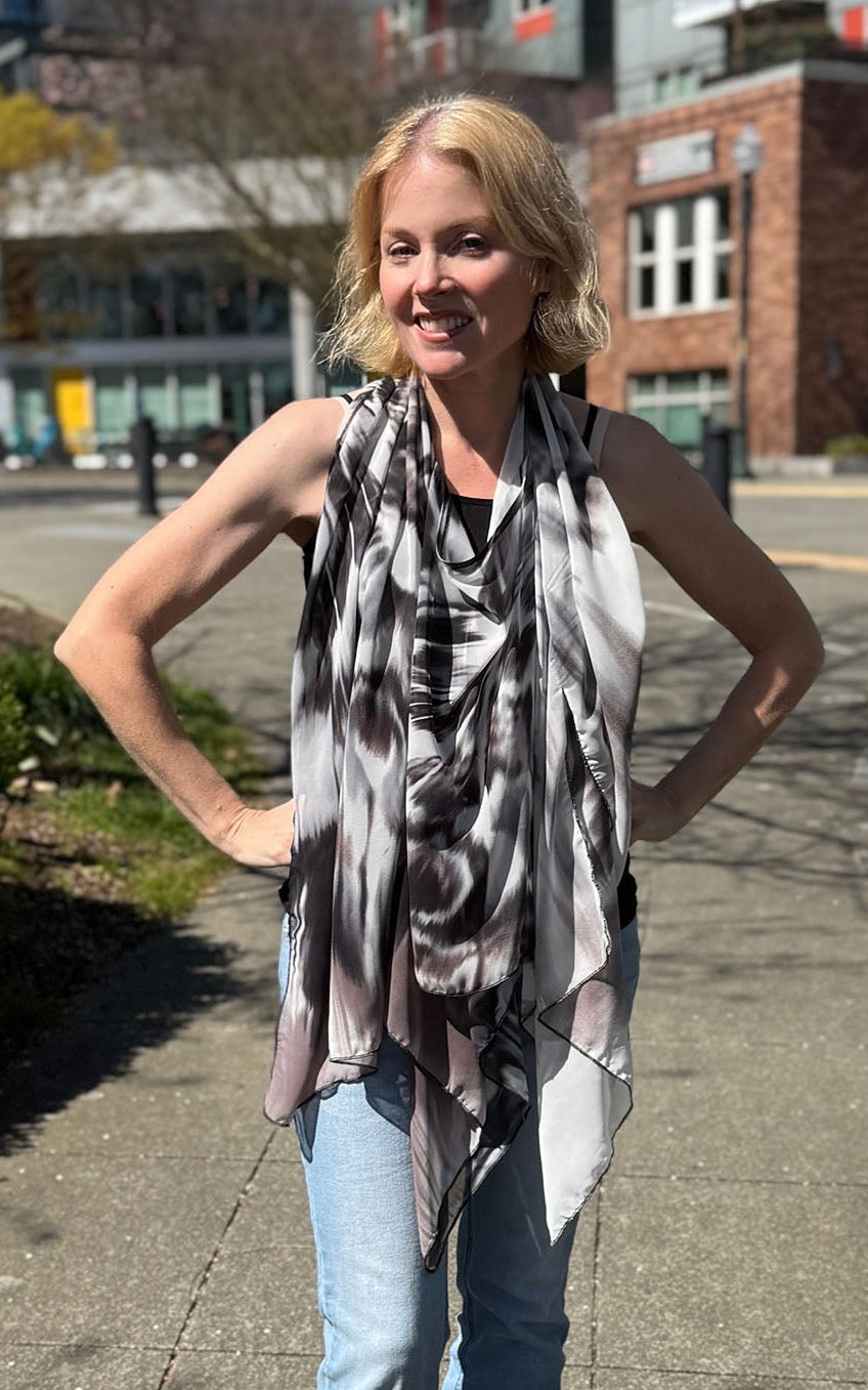 Woman wearing the Lumina Poncho in Social Butterfly, shown styled as a scarf. Made in Seattle, WA, USA by Pandemonium Seattle.